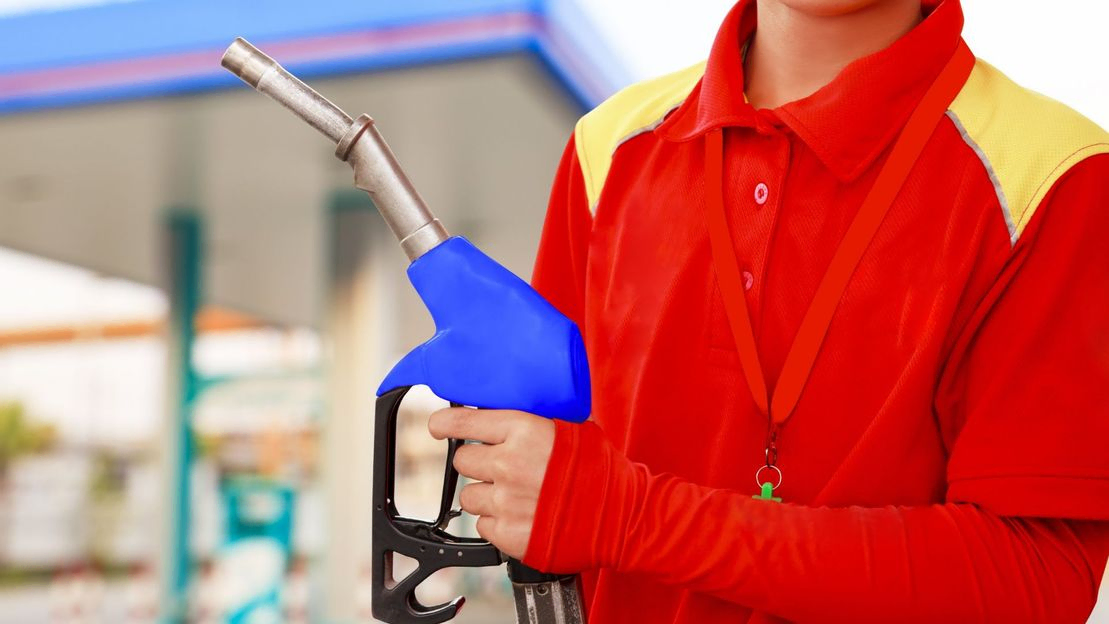 Trabajador sosteniendo manguera dispensadora de gasolina